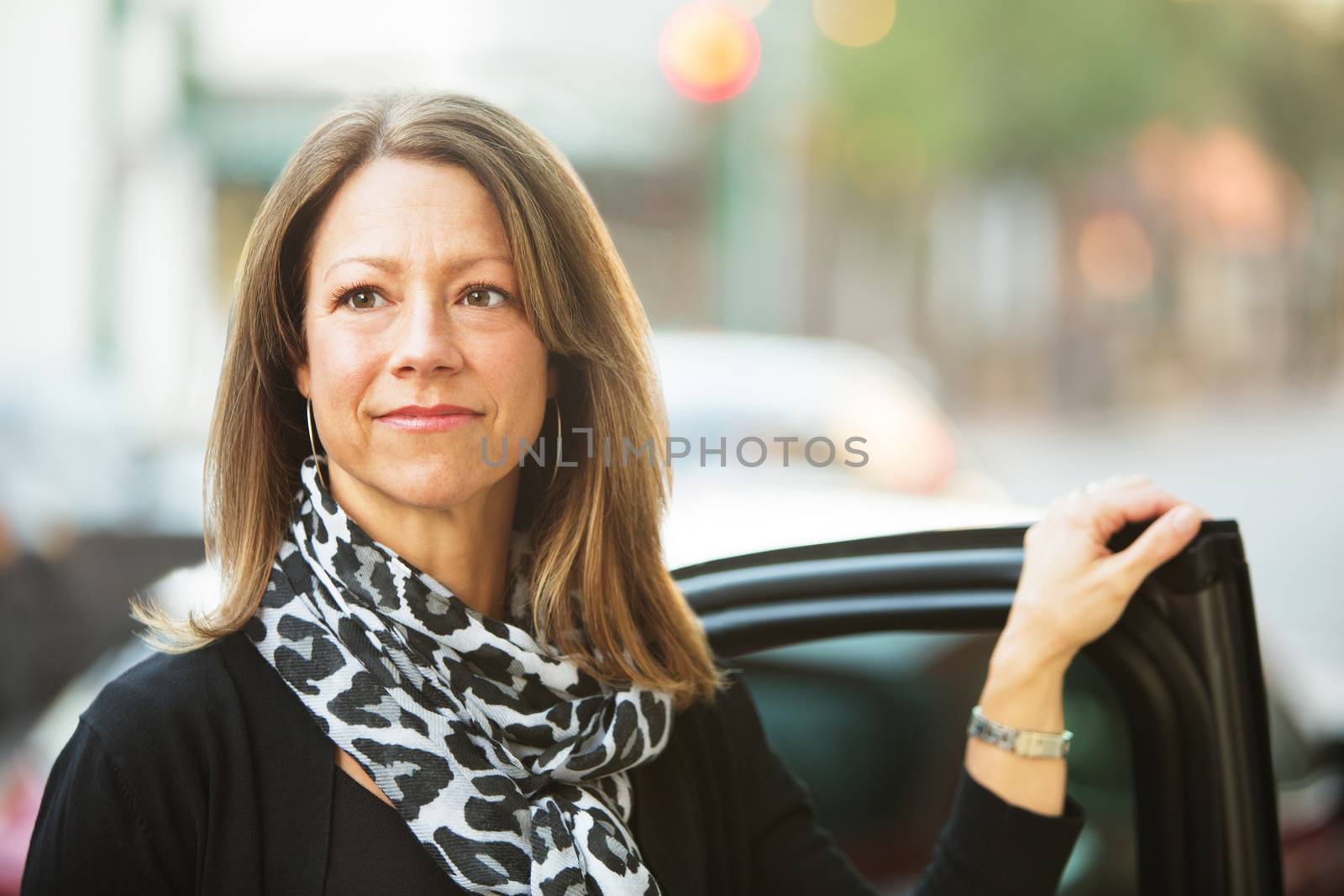 Confident European business woman standing near car door