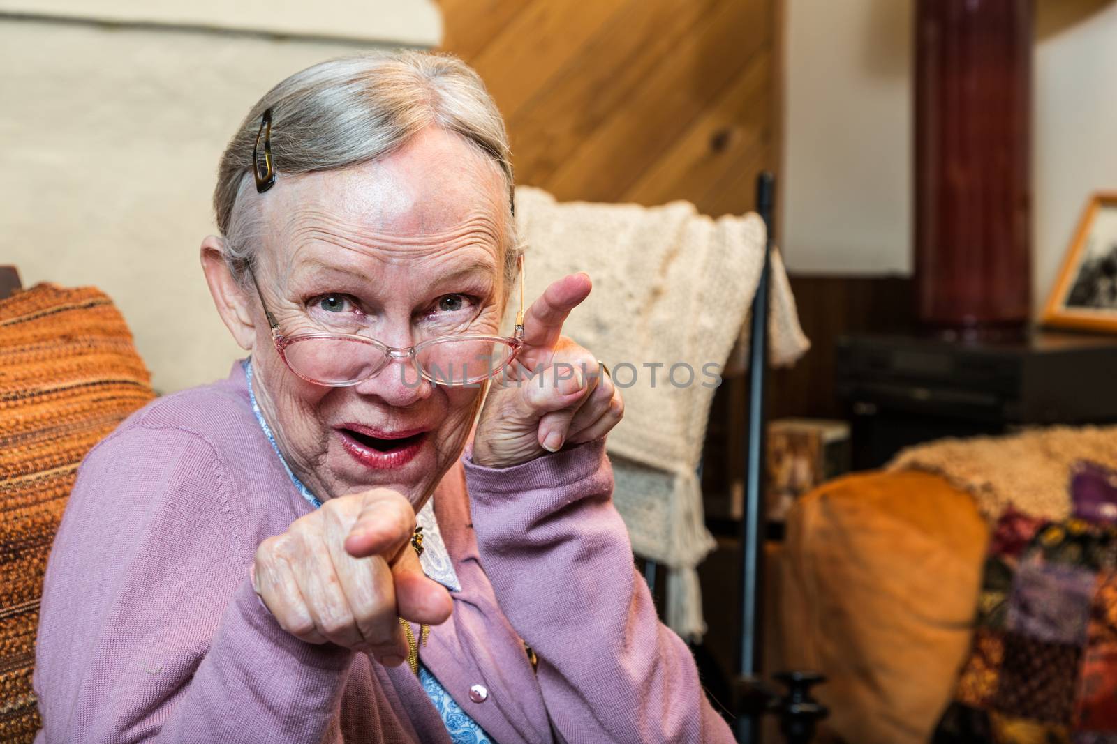 Funny old woman in pink sweater showing dance style hand gesture