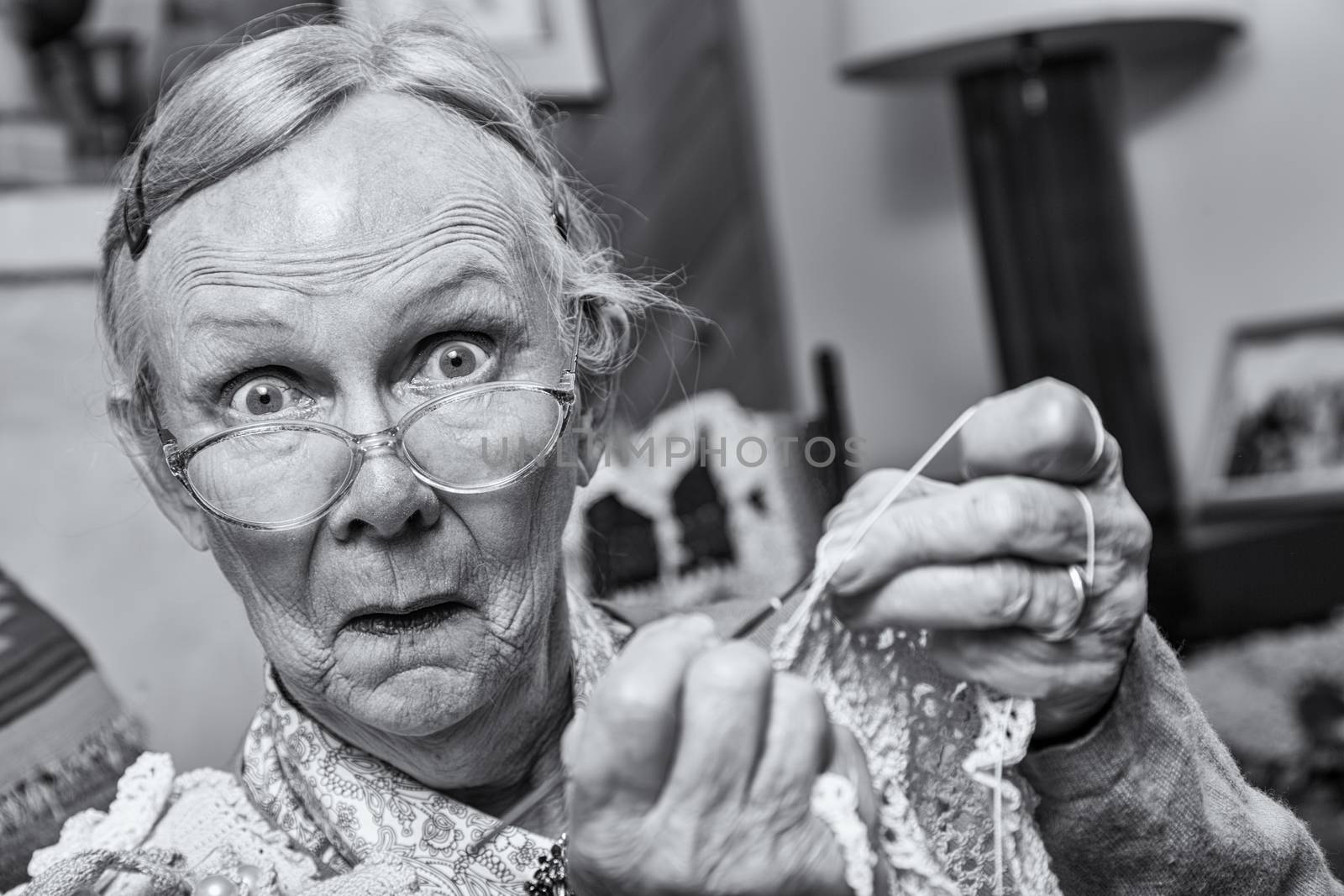 Surprised woman crocheting while looking at camera
