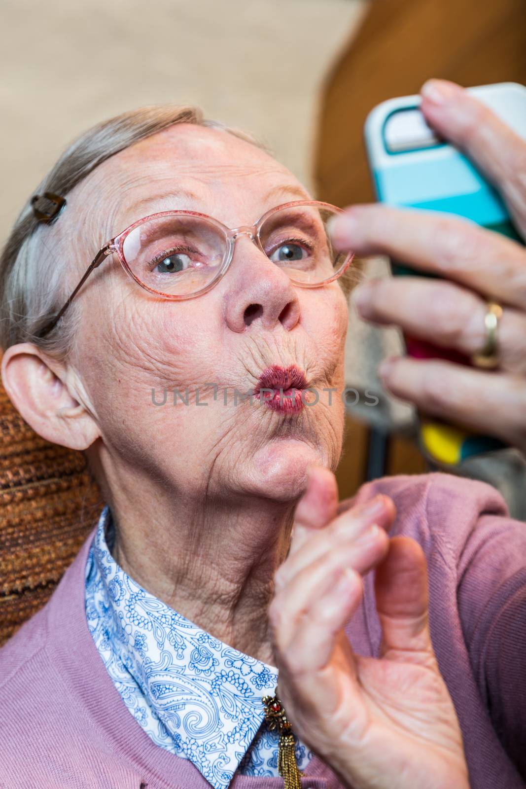 Happy elder woman taking duck face selfie