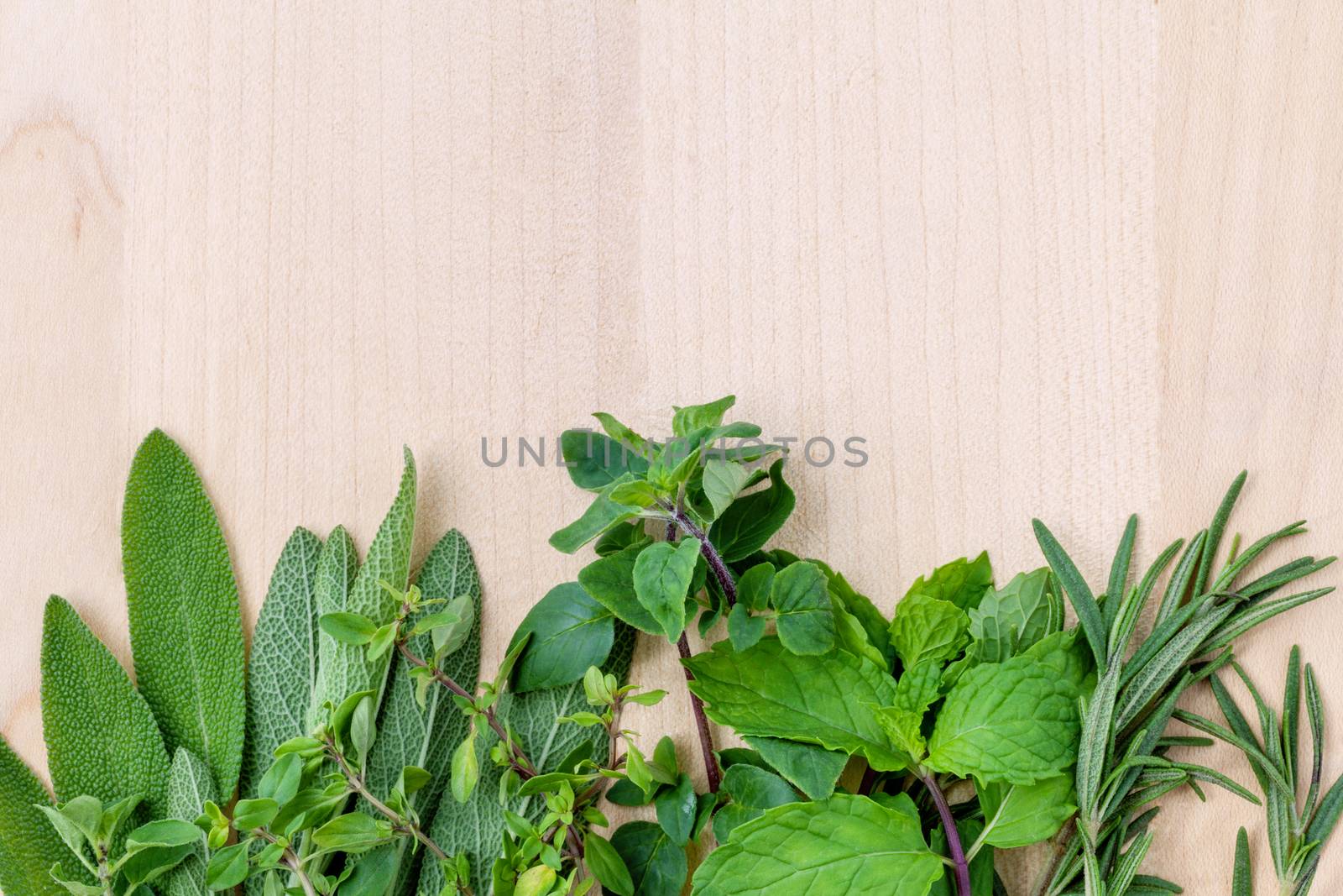 Fresh green herbs harvest from garden on wooden rustic background .