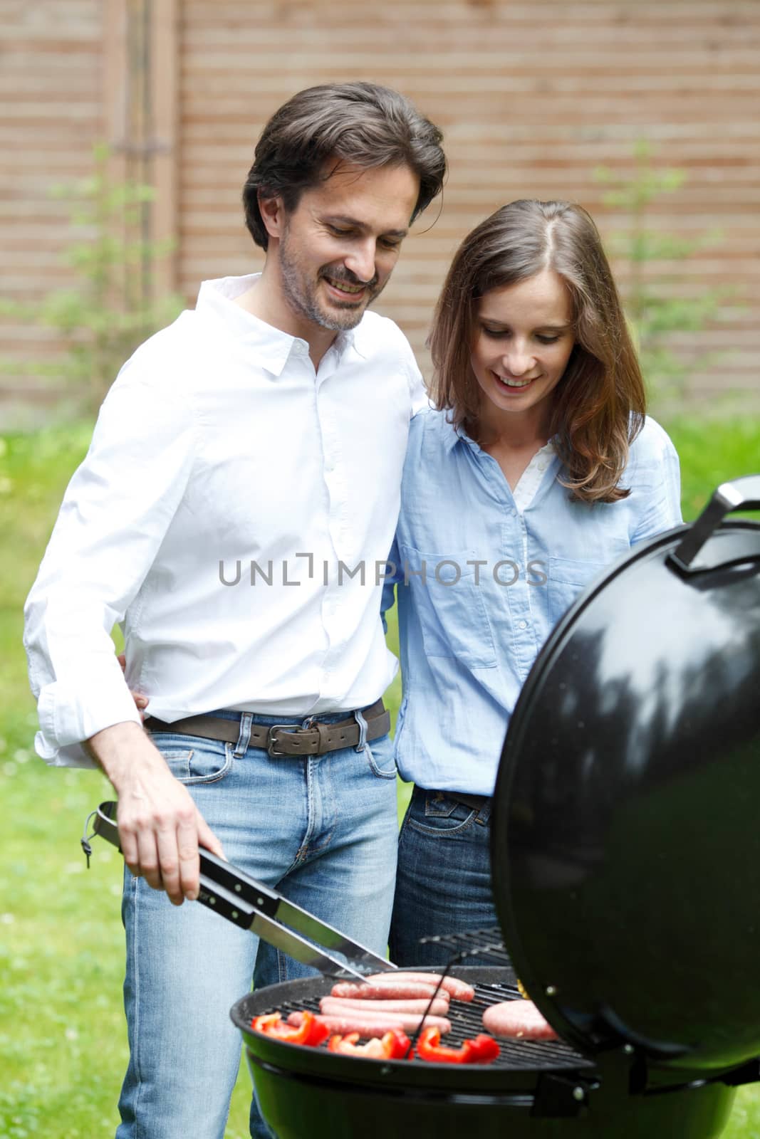 couple cooking on grill outdoors
