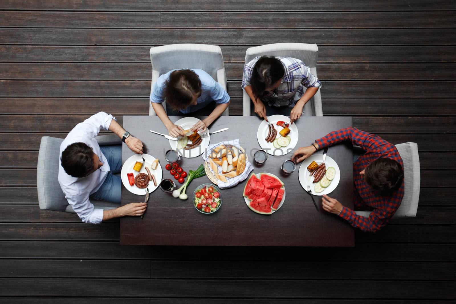 two young couples eating dinner behind table