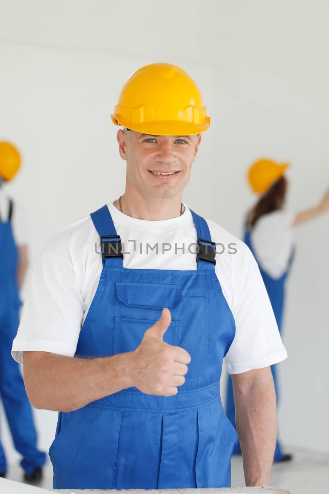 workman gives thumbs up in front of two painters