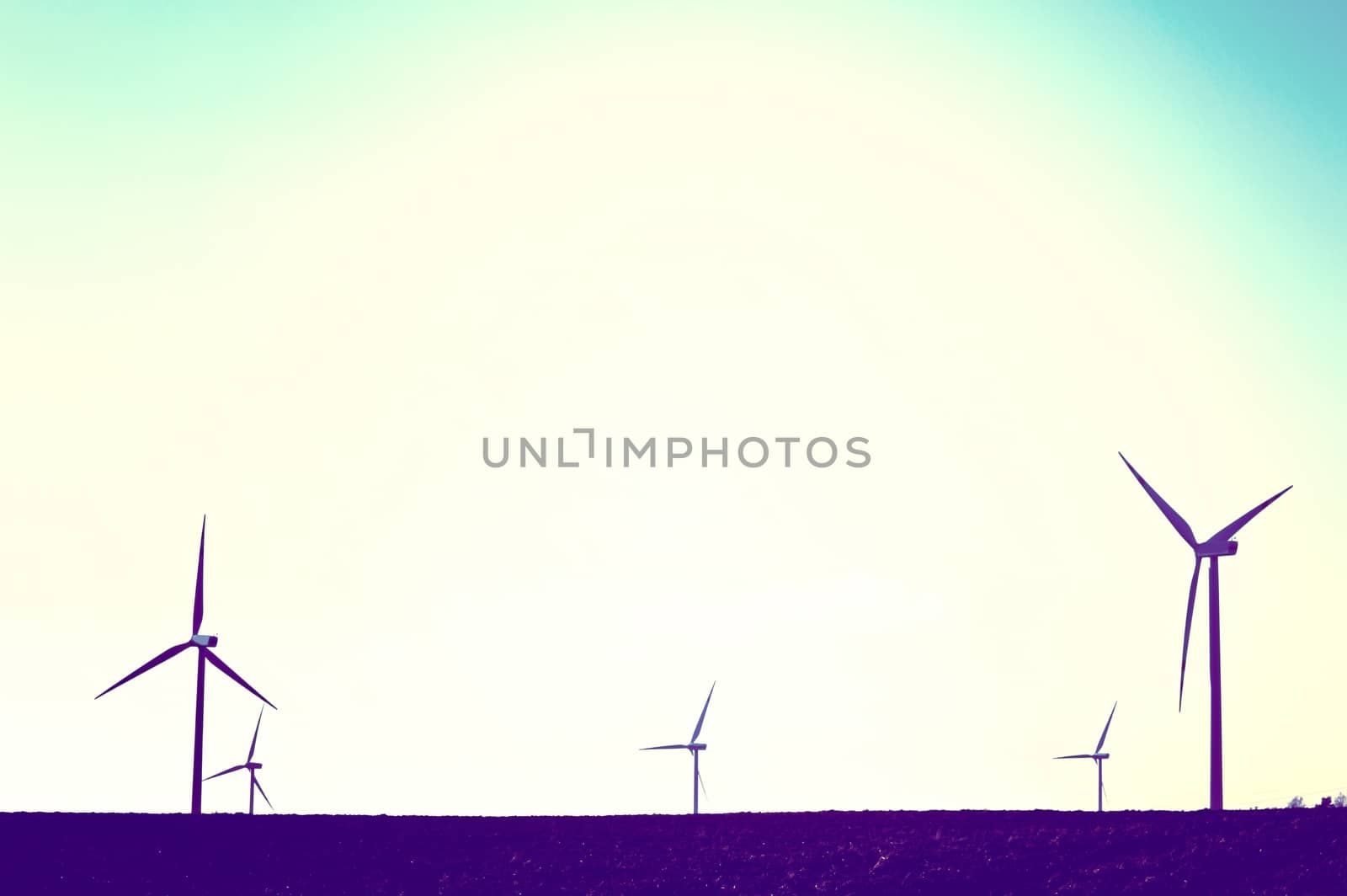 Windmills on the field. Vintage instagram picture. Alternative energy.