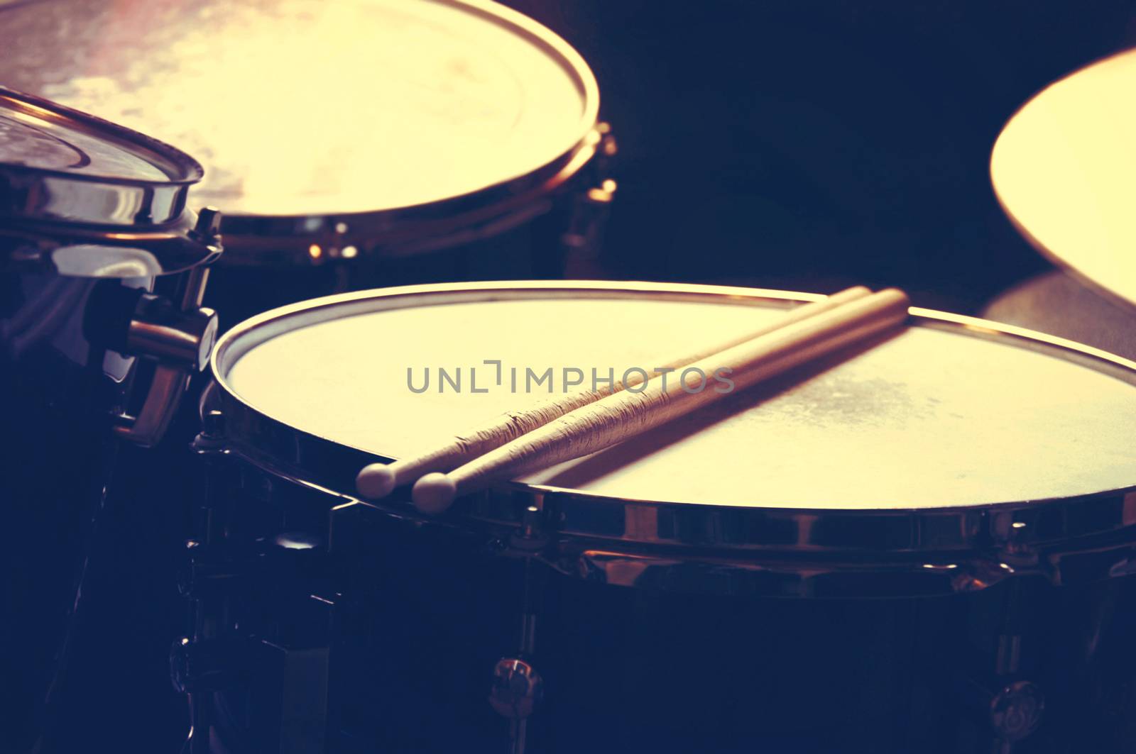 Drums conceptual image. Picture of drums and drumsticks lying on snare drum. Retro vintage instagram picture.