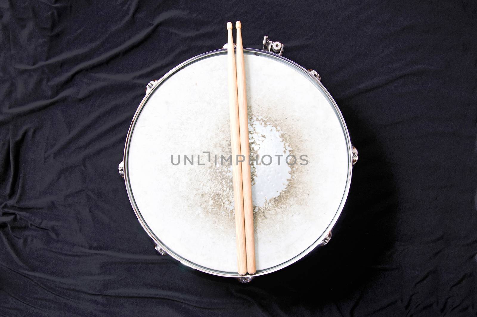 Drums conceptual image. Snare drum and stick over black background.