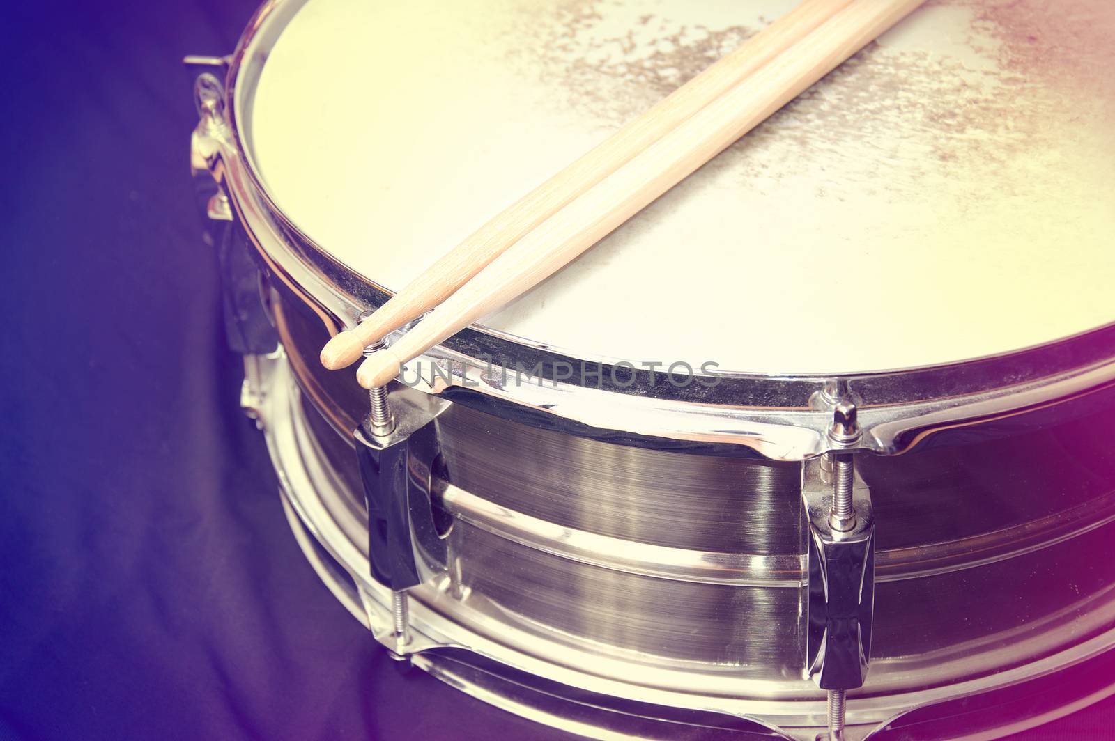 Drums conceptual image. Picture of drums and drumsticks lying on snare drum. Retro vintage instagram picture.