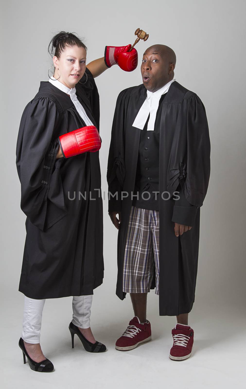 woman hammering a man on the head with a gavel, both wearing canadian lawyers toga