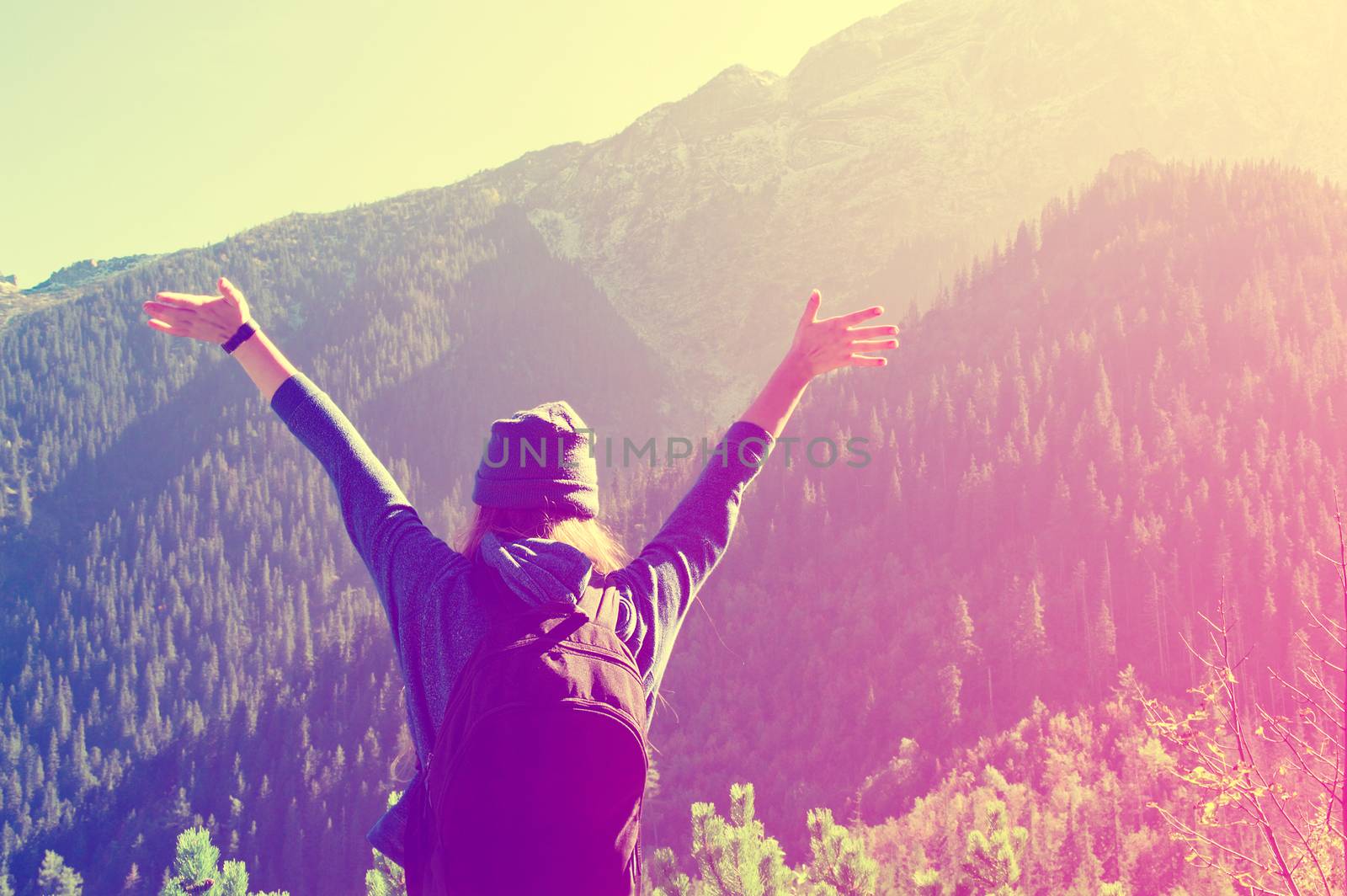 Happy teenage girl feel freedom in mountains scenery. Vintage instagram picture.