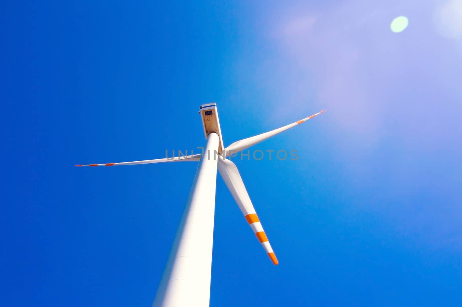 Wind turbine against blue sky. Windmill alternative ecological energy.