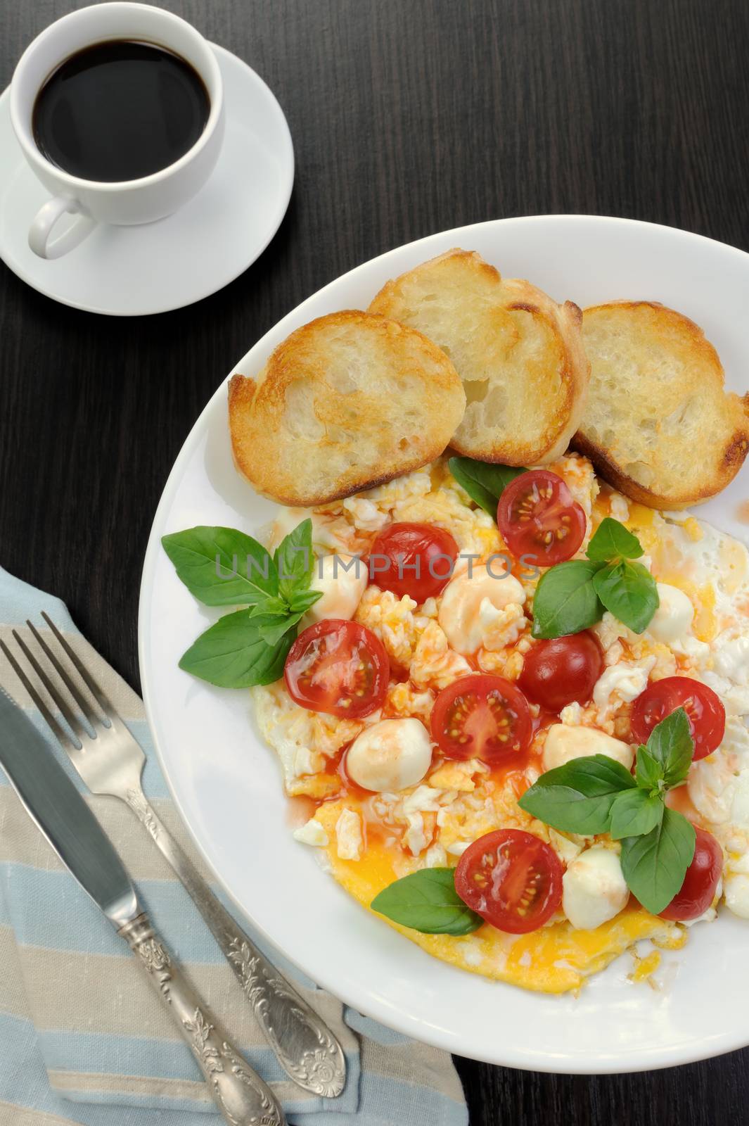 Scrambled eggs with cherry tomatoes, mozzarella and croutons