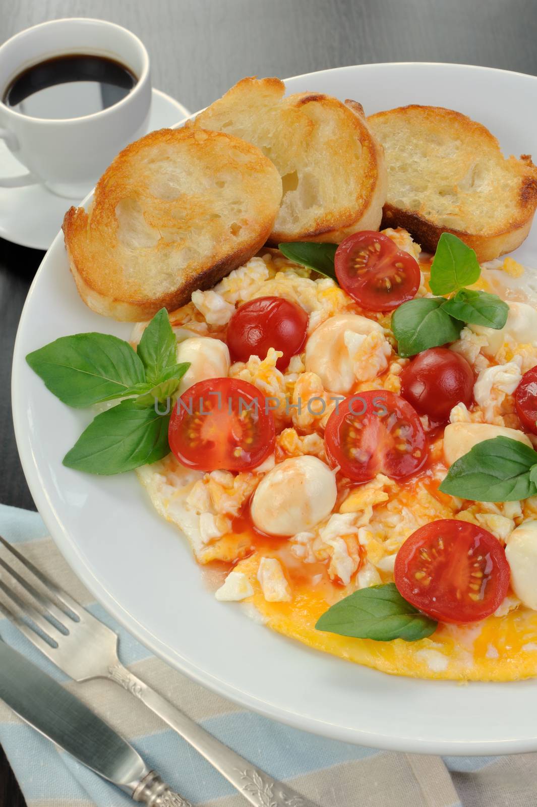 Scrambled eggs with cherry tomatoes, mozzarella and croutons