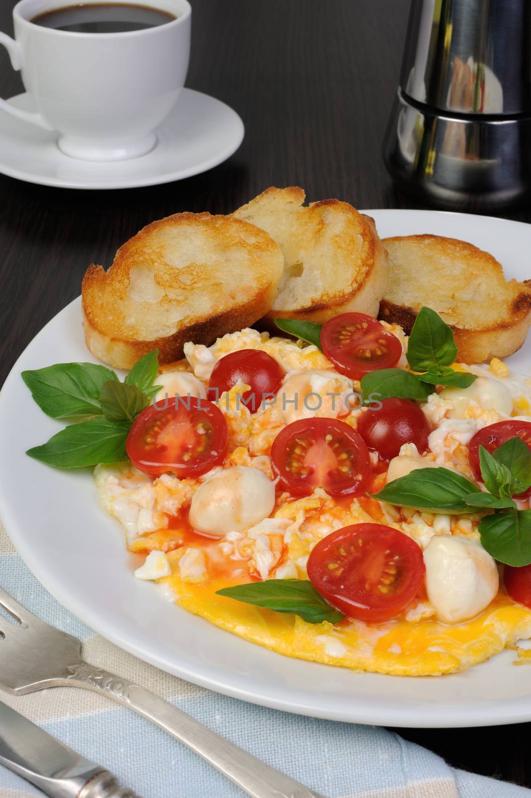 Scrambled eggs with cherry tomatoes, mozzarella and croutons