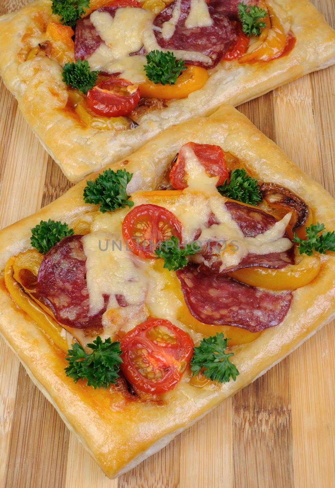 Mini pizza with vegetables, salami and cheese