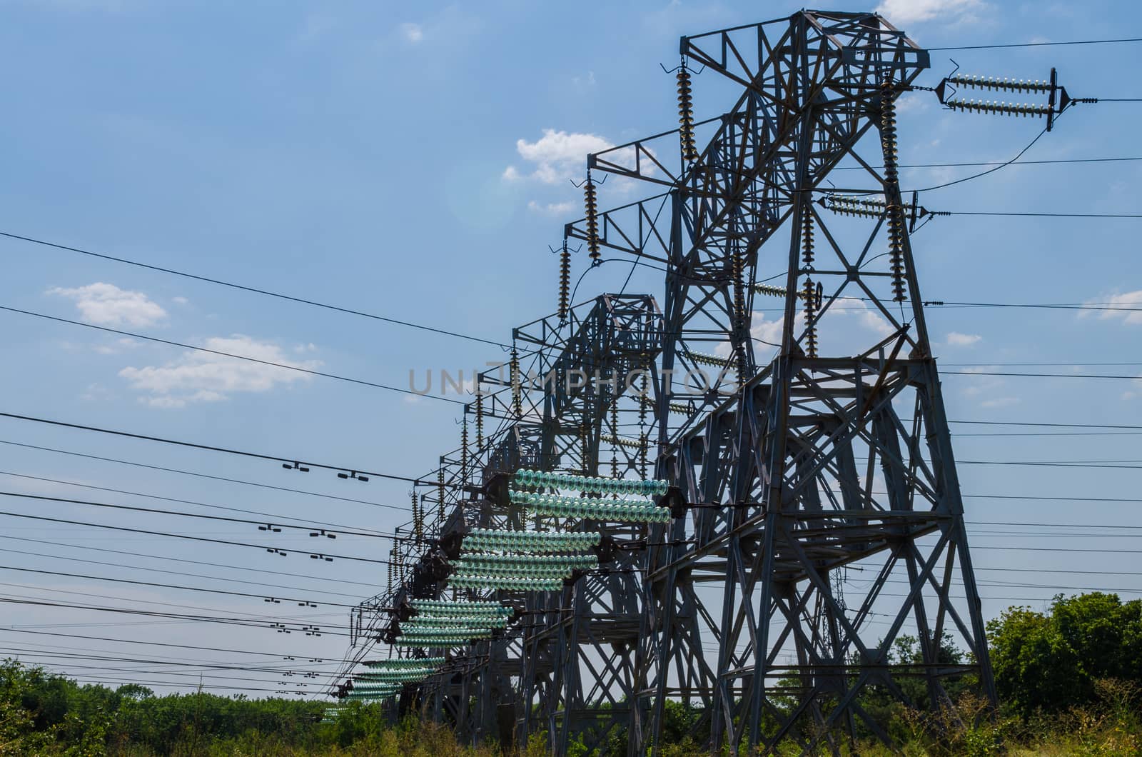 supports of high-voltage power lines against the blue sky