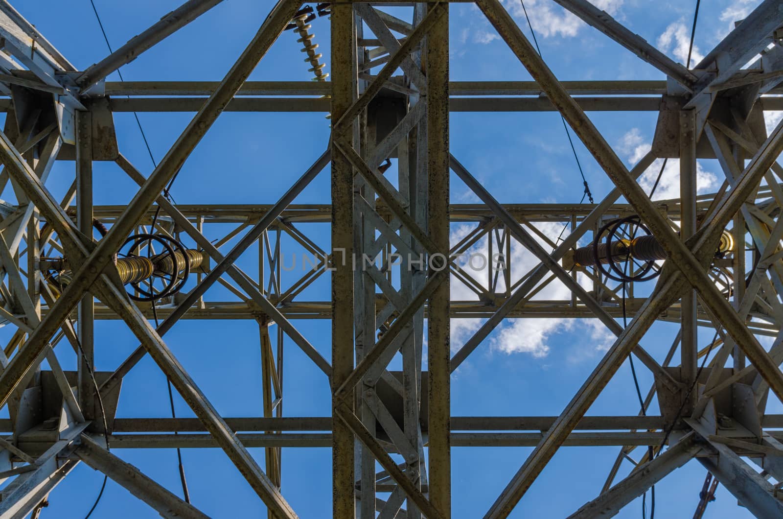 supports of high-voltage power lines against the blue sky