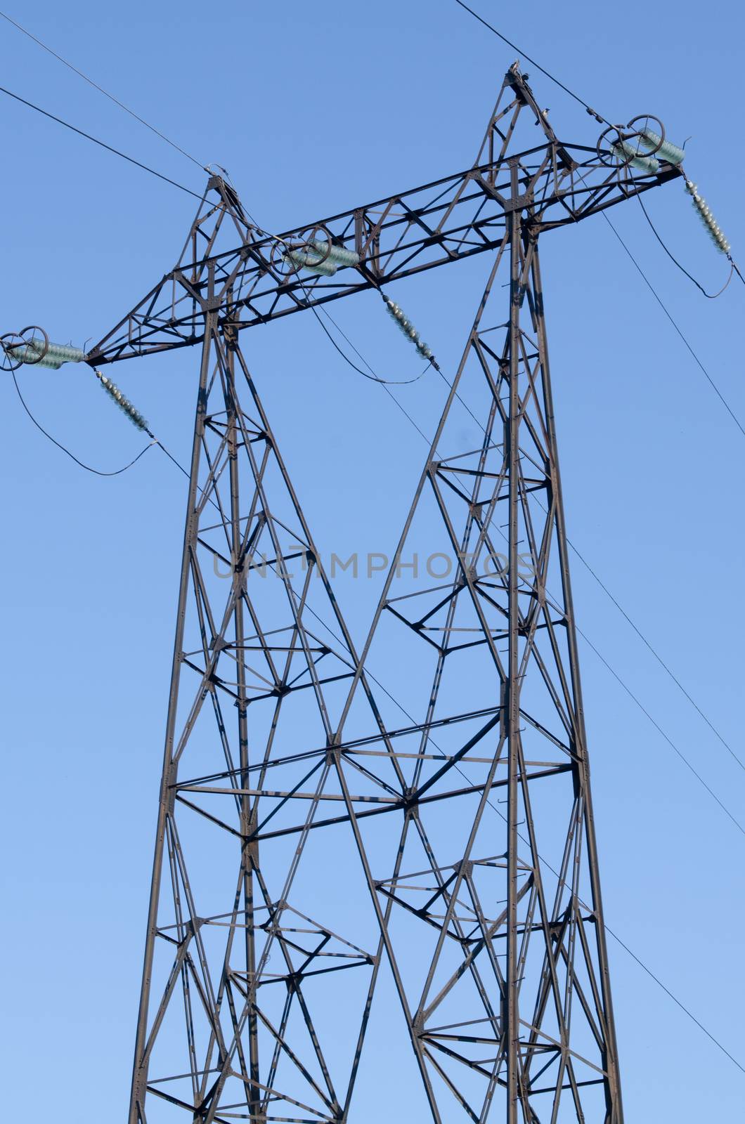 supports of high-voltage power lines against the blue sky