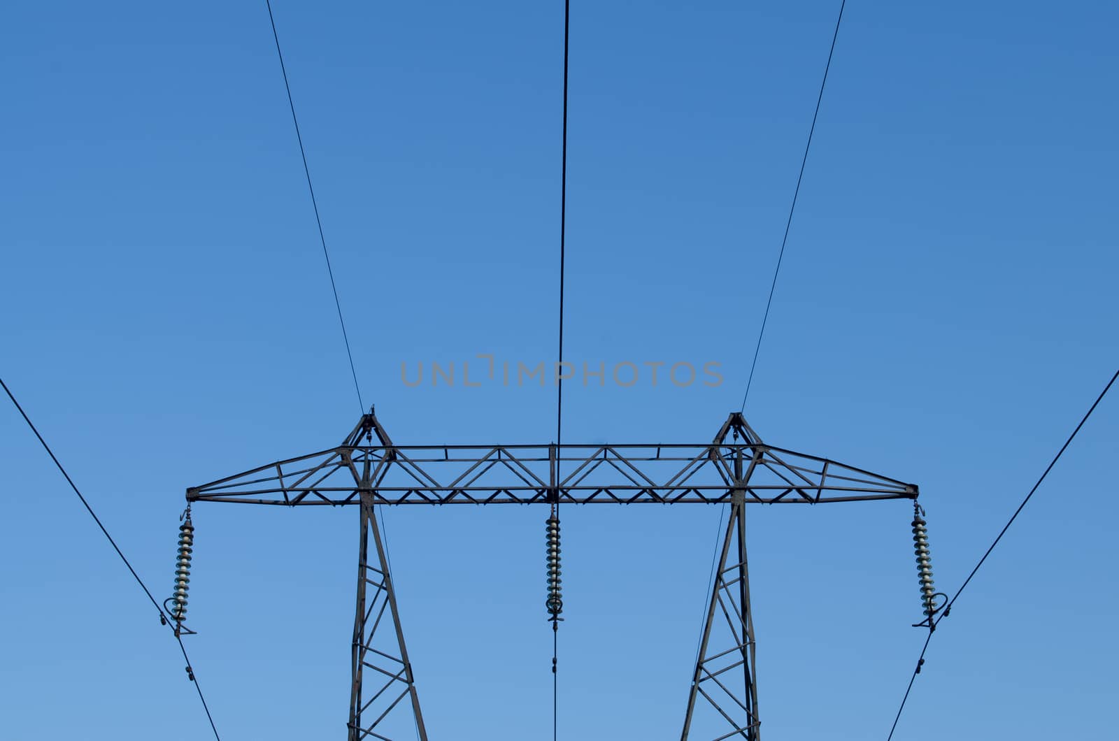 supports of high-voltage power lines against the blue sky