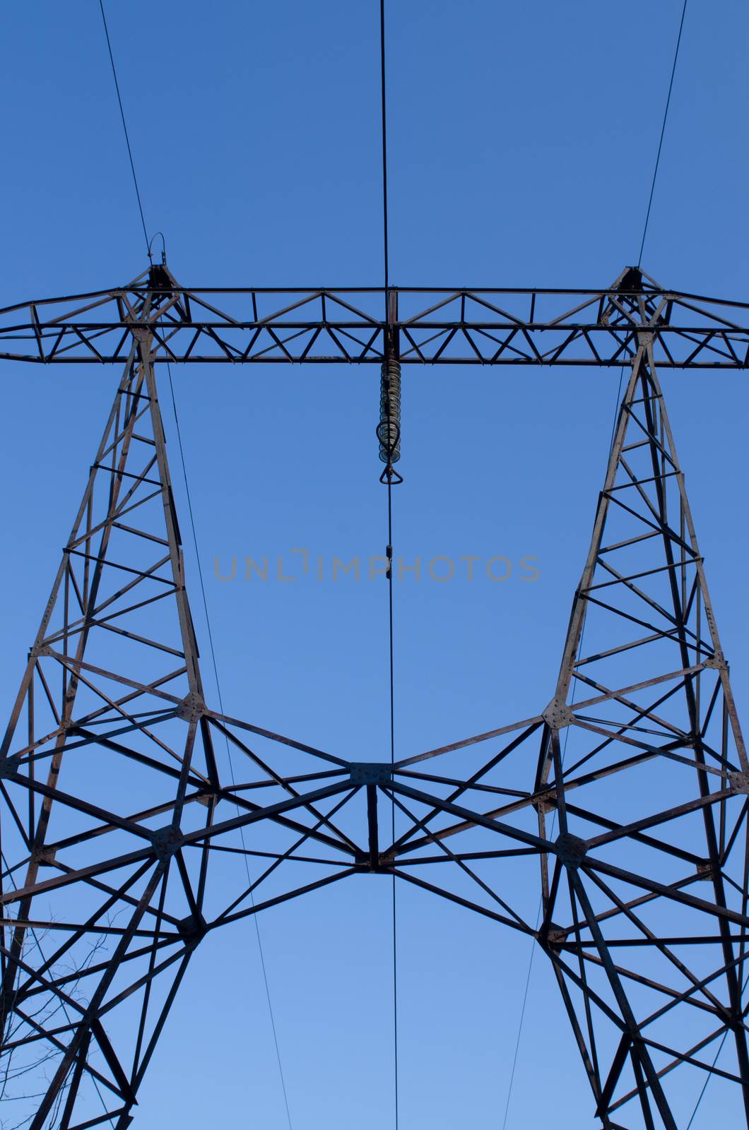 supports of high-voltage power lines against the blue sky