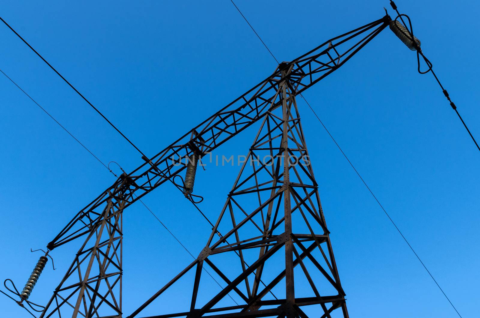 supports of high-voltage power lines against the blue sky