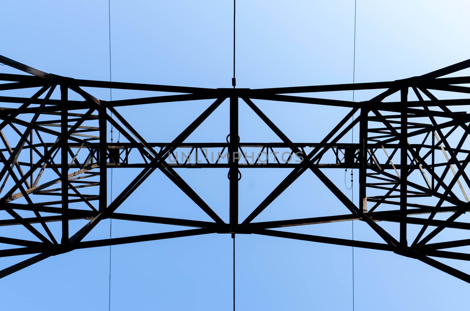 supports of high-voltage power lines against the blue sky