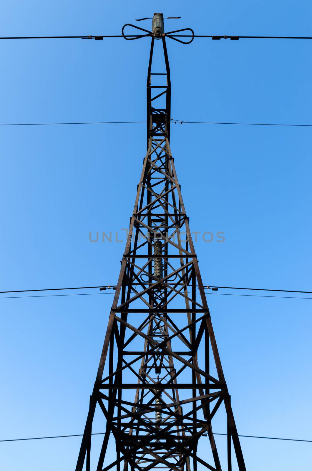 supports of high-voltage power lines against the blue sky