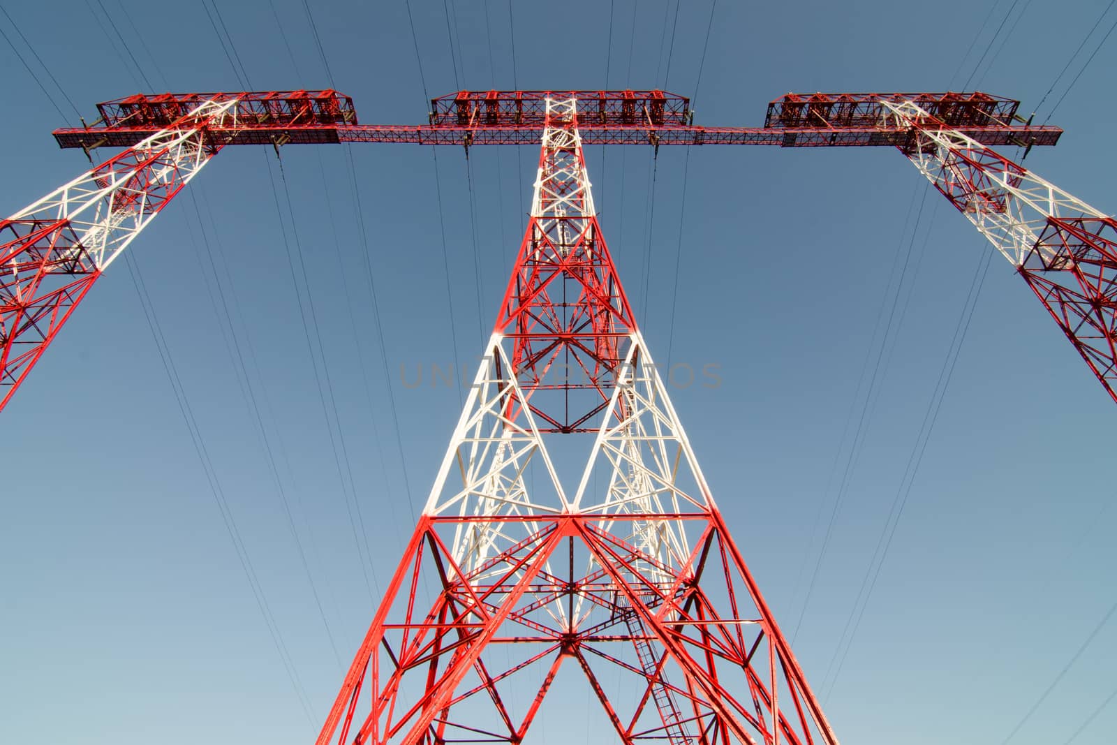 supports of high-voltage power lines against the blue sky