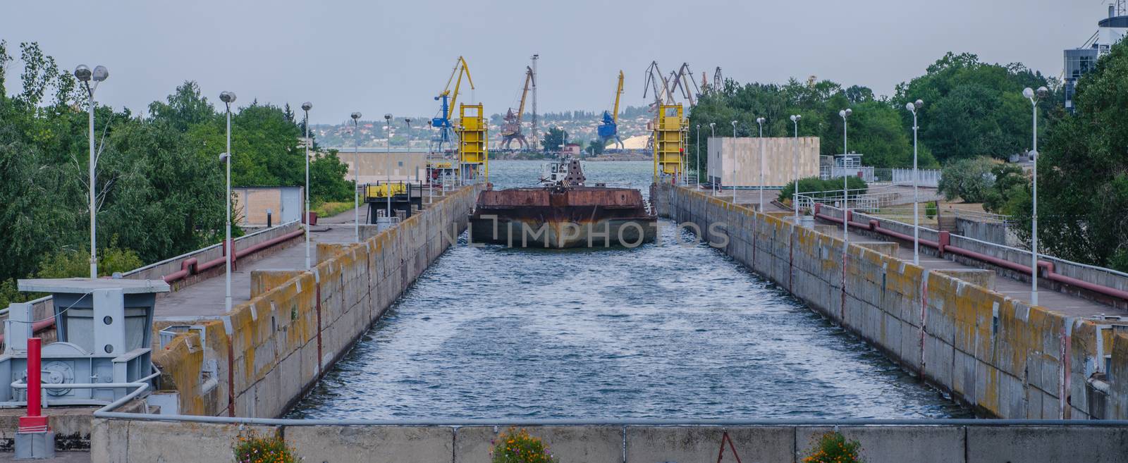 a cargo barge in the lock of a water dam