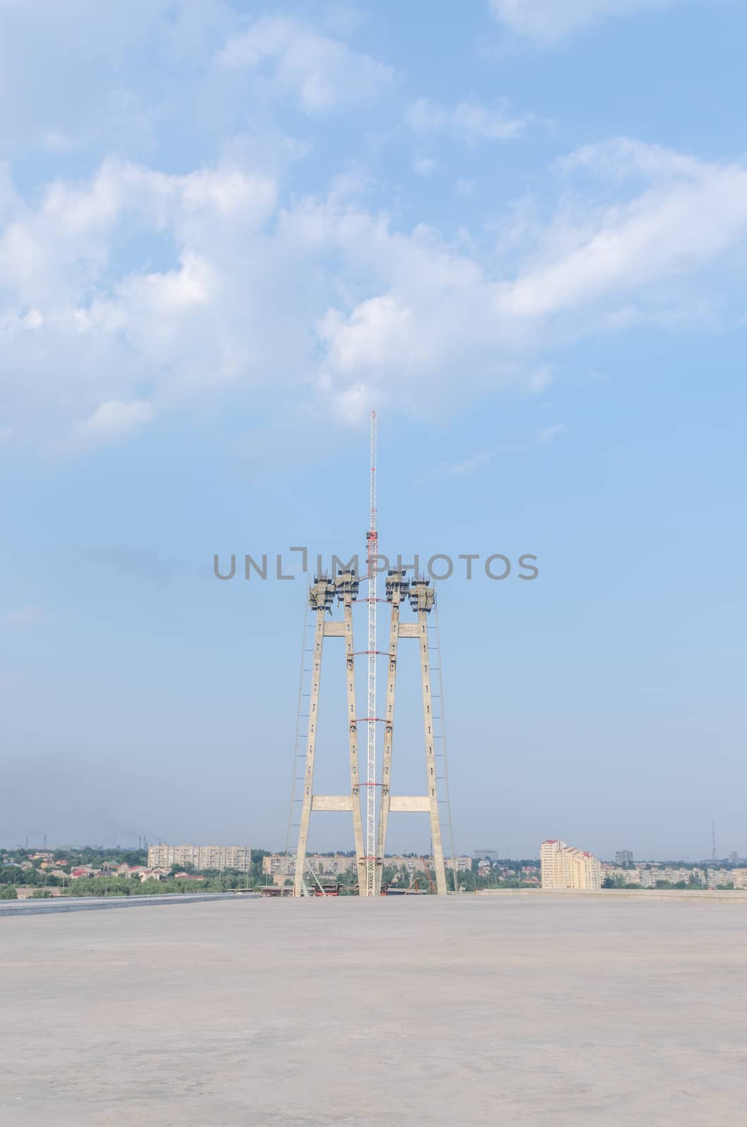 the construction of a bridge across the river with the supports, structural elements, cranes