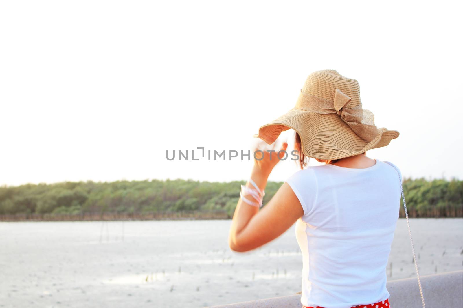 Lady at the beach with her brown hat