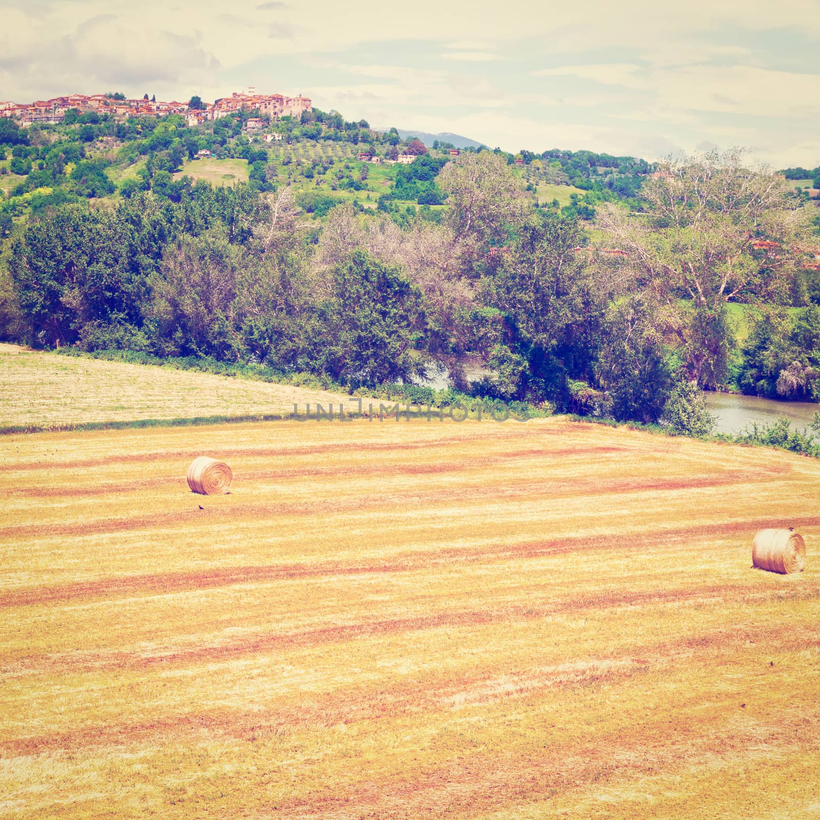 Tuscany Landscape with Many Hay Bales on the Background of the Medieval City, Instagram Effect