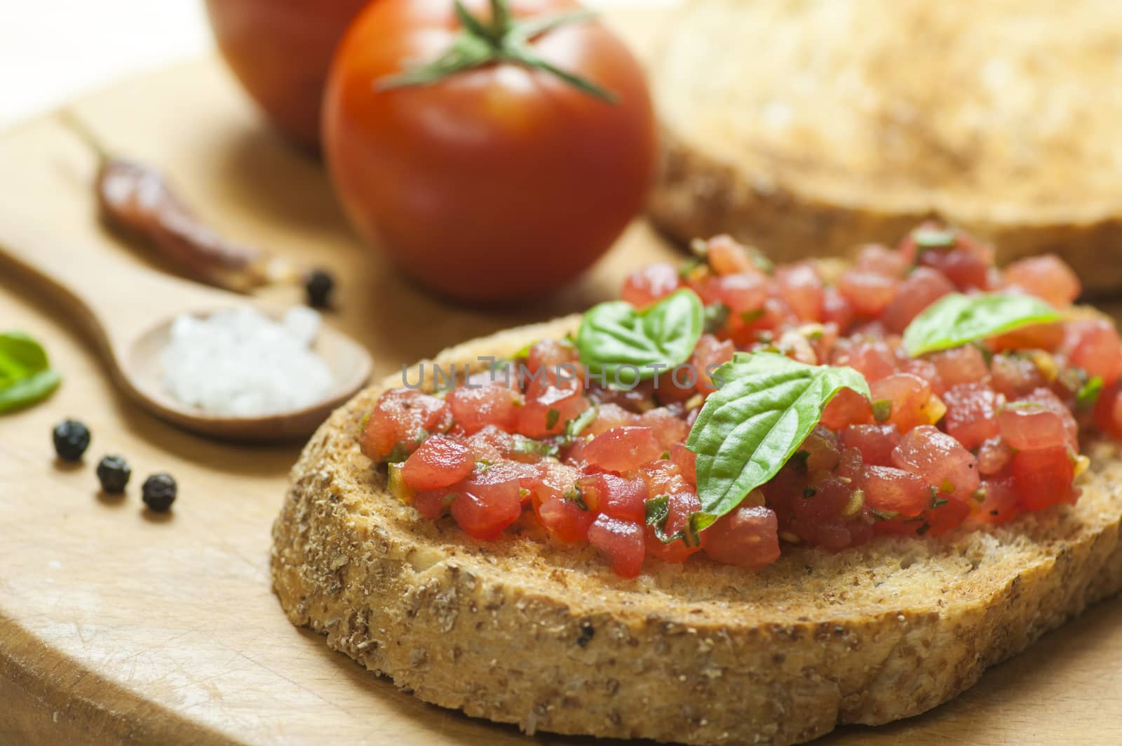 Italian bruschetta topped with tomatoes and basil, close up