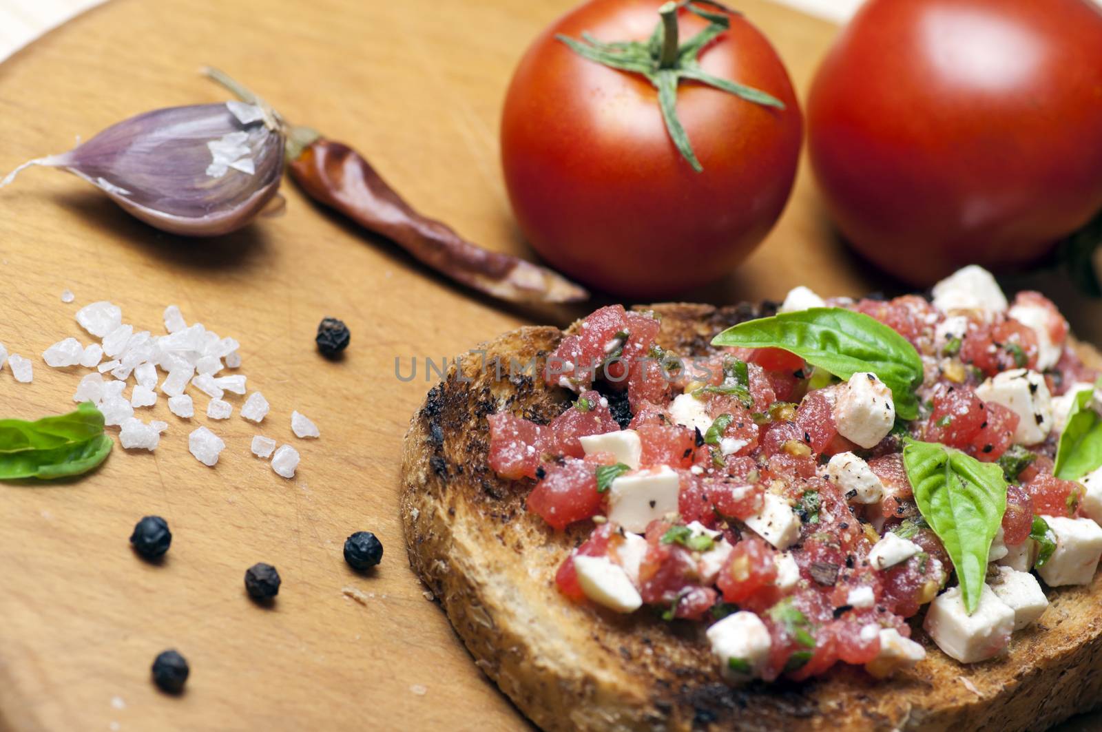 Italian bruschetta topped with tomatoes, basil and goat (feta) cheese
