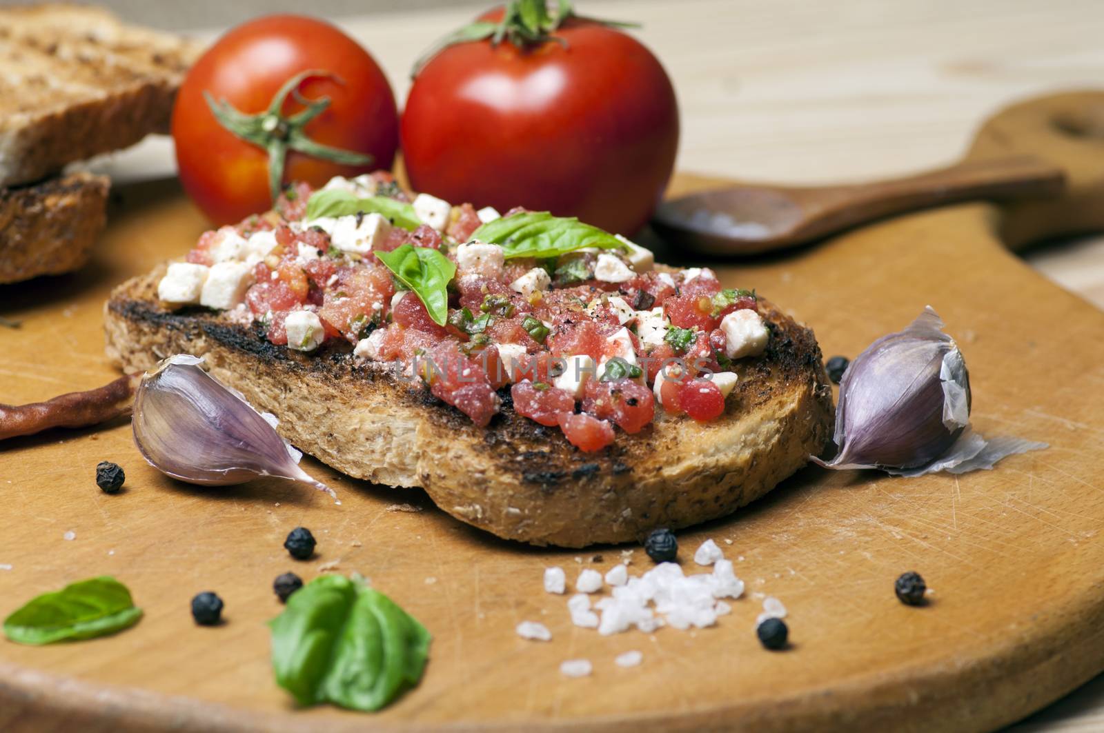 Italian bruschetta topped with tomatoes, basil and goat (feta) cheese