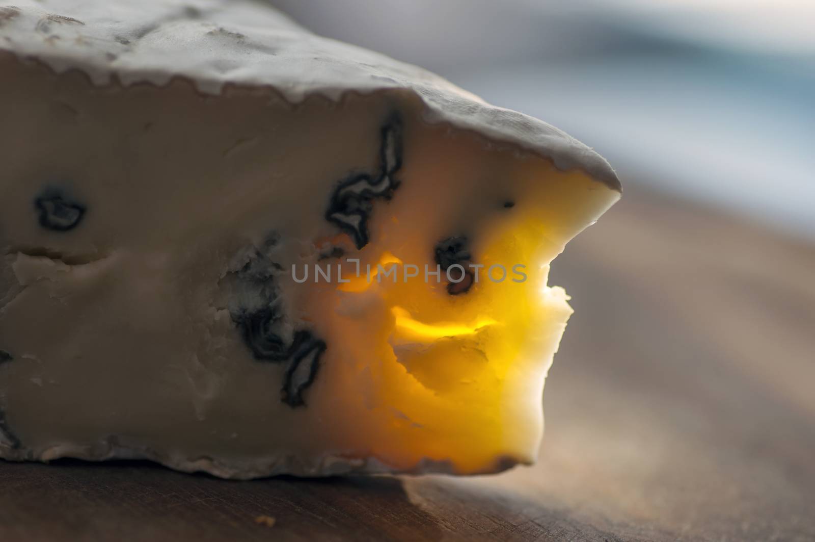 Cambozola cheese (combination of camembert and gorgonzola cheeses) on cutting board close up