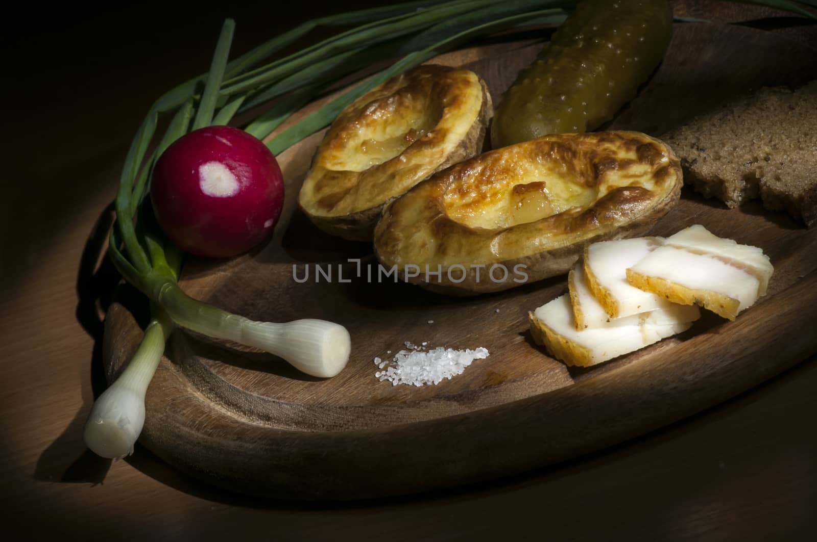 Baked potatoes in their jacket served with salted lard and green onion