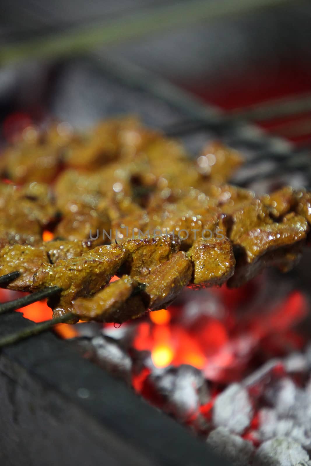 Delicious looking juicy mutton kebabs cooking on a a barbecue 