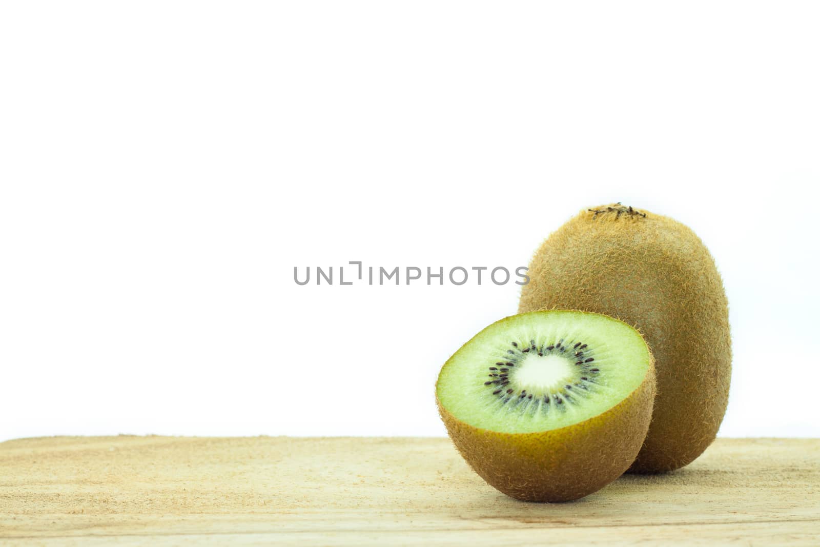 Fresh kiwis on wooden ground  isolated on white background