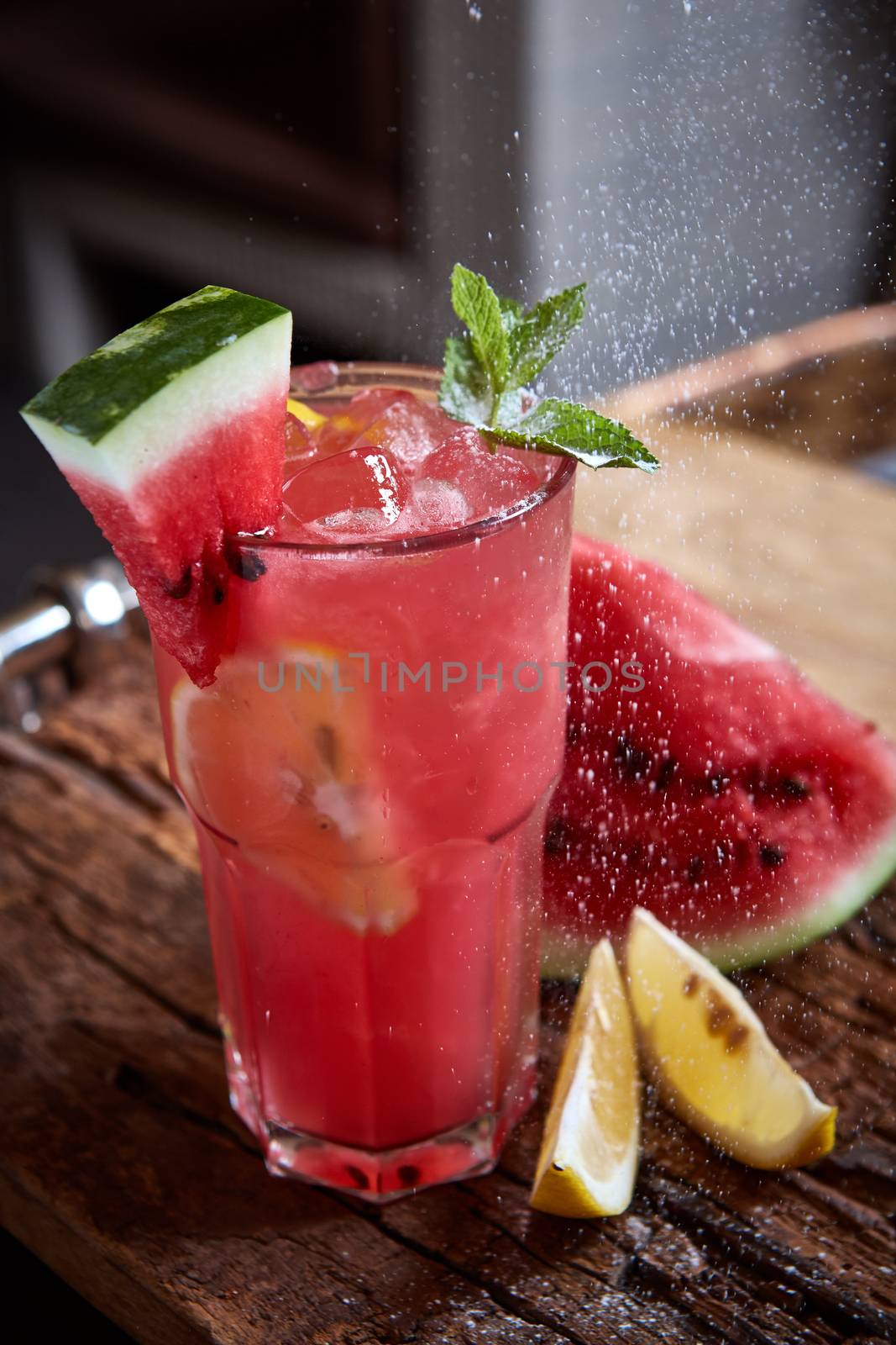 Homemade watermelon lemonade with mint and lemon in glasses and slices of watermelon