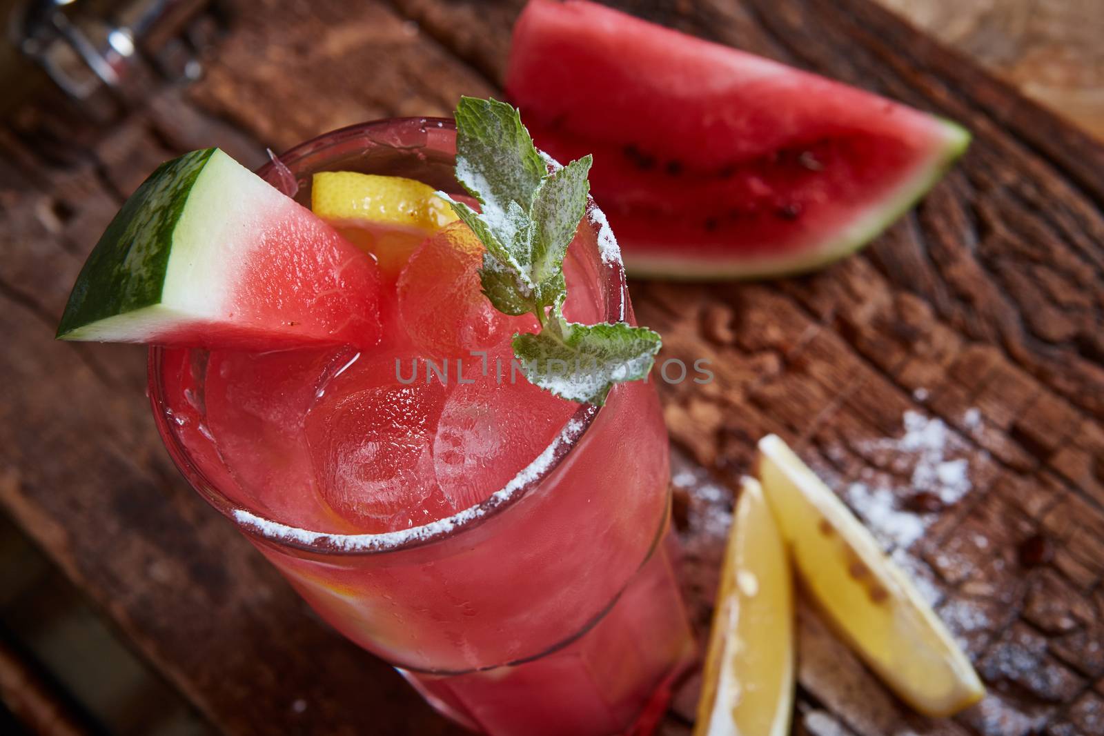 Homemade watermelon lemonade with mint and lemon in glasses and slices of watermelon