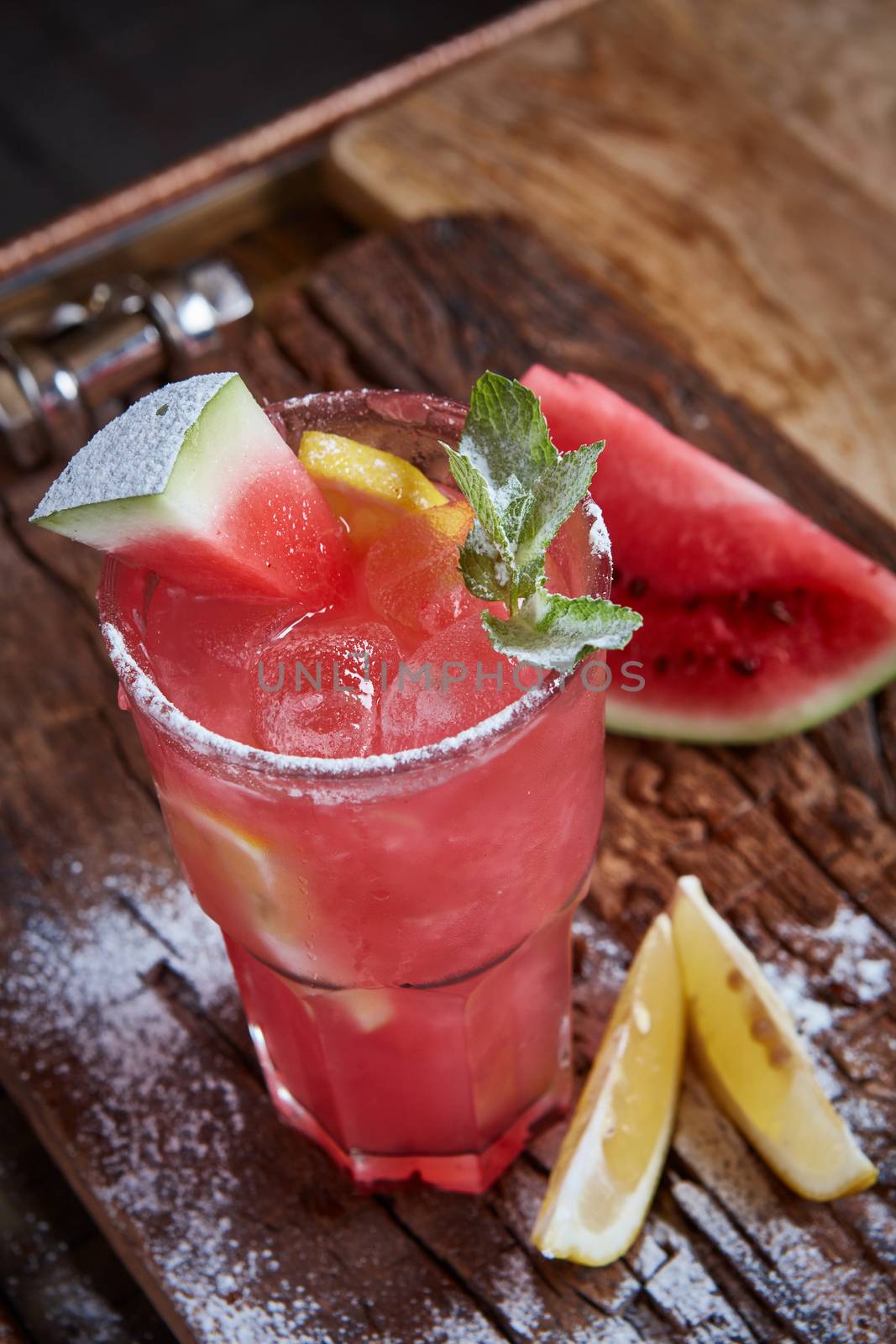 Homemade watermelon lemonade with mint and lemon in glasses and slices of watermelon