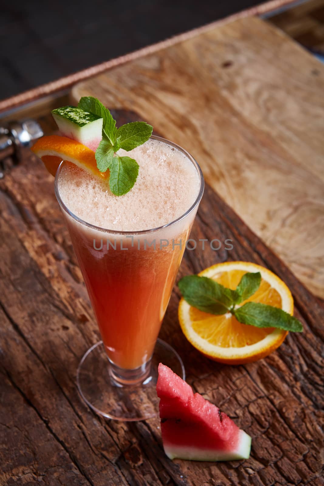 glass watermelon and orange smoothie with copy space on wooden background