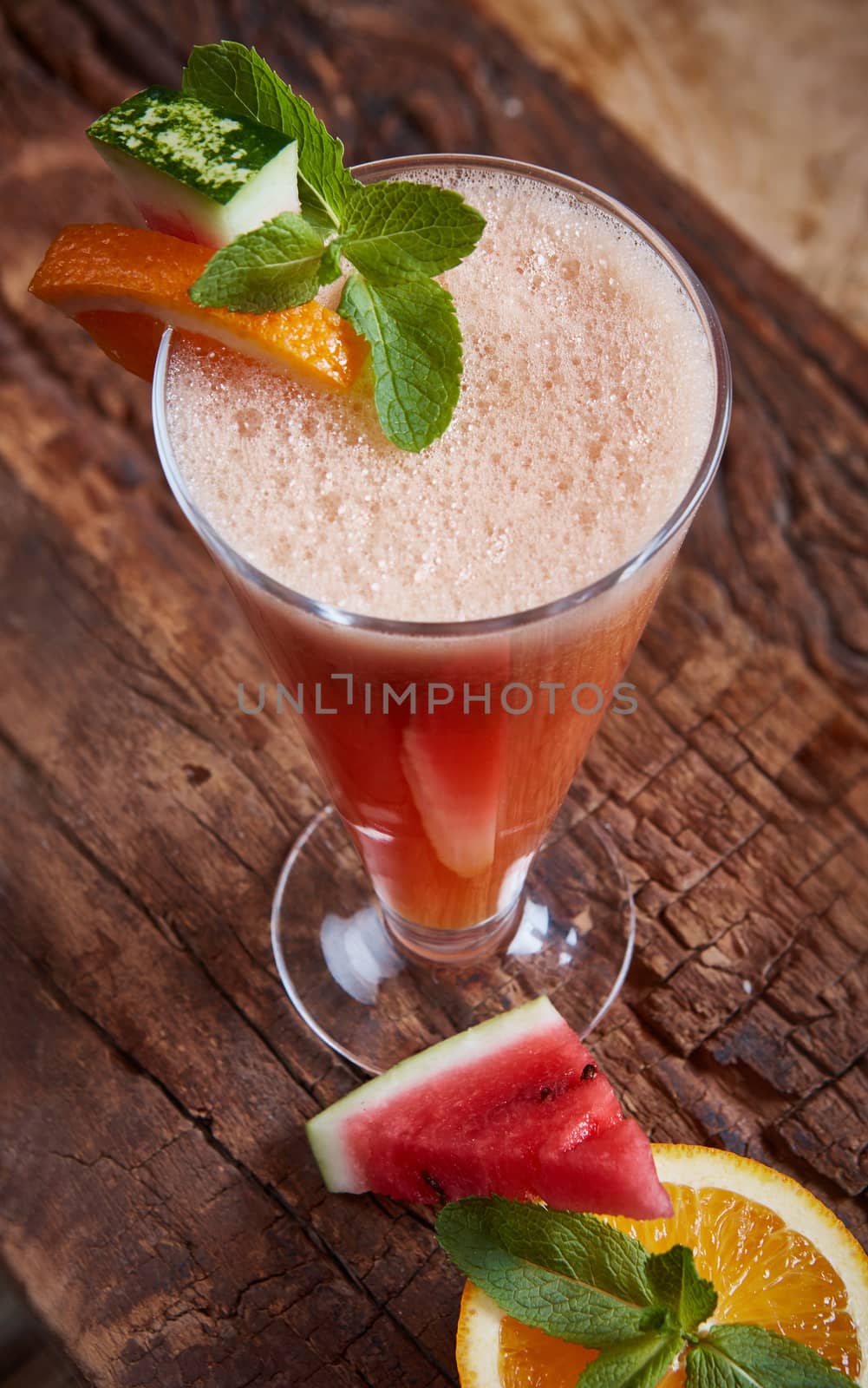 glass watermelon and orange smoothie with copy space on wooden background