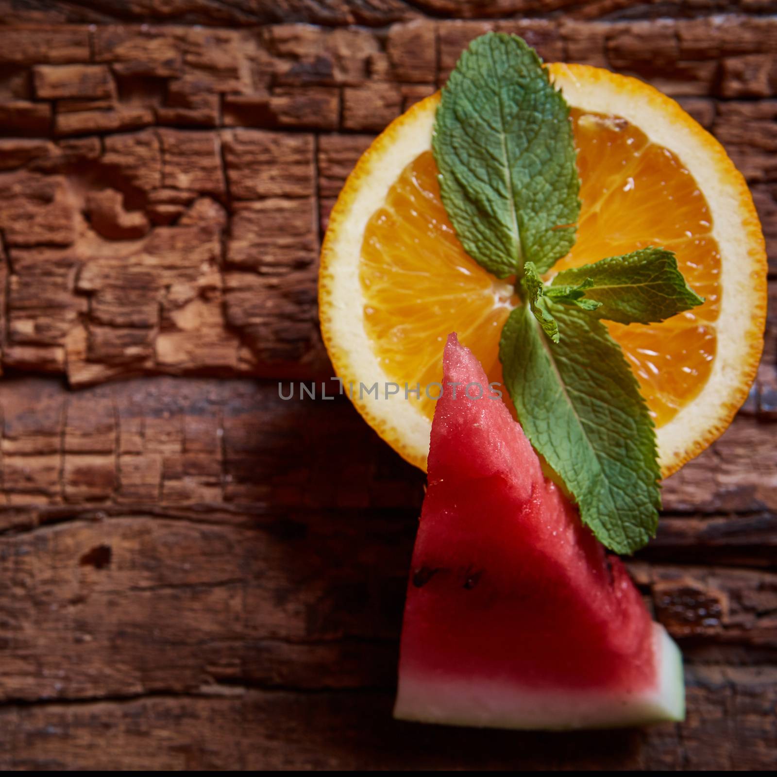 Watermelon, mint and orange with copy space on the wooden background