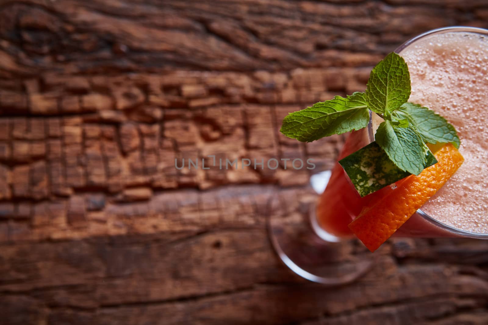 glass watermelon and orange smoothie with copy space on wooden background