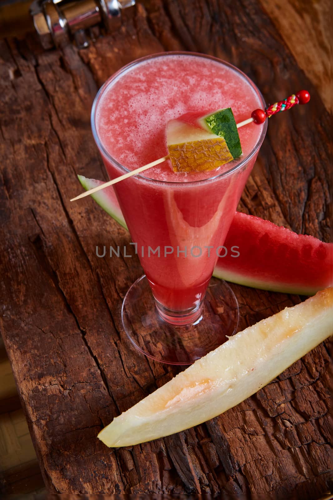 Healthy watermelon and melon smoothie with copy space on a wood background