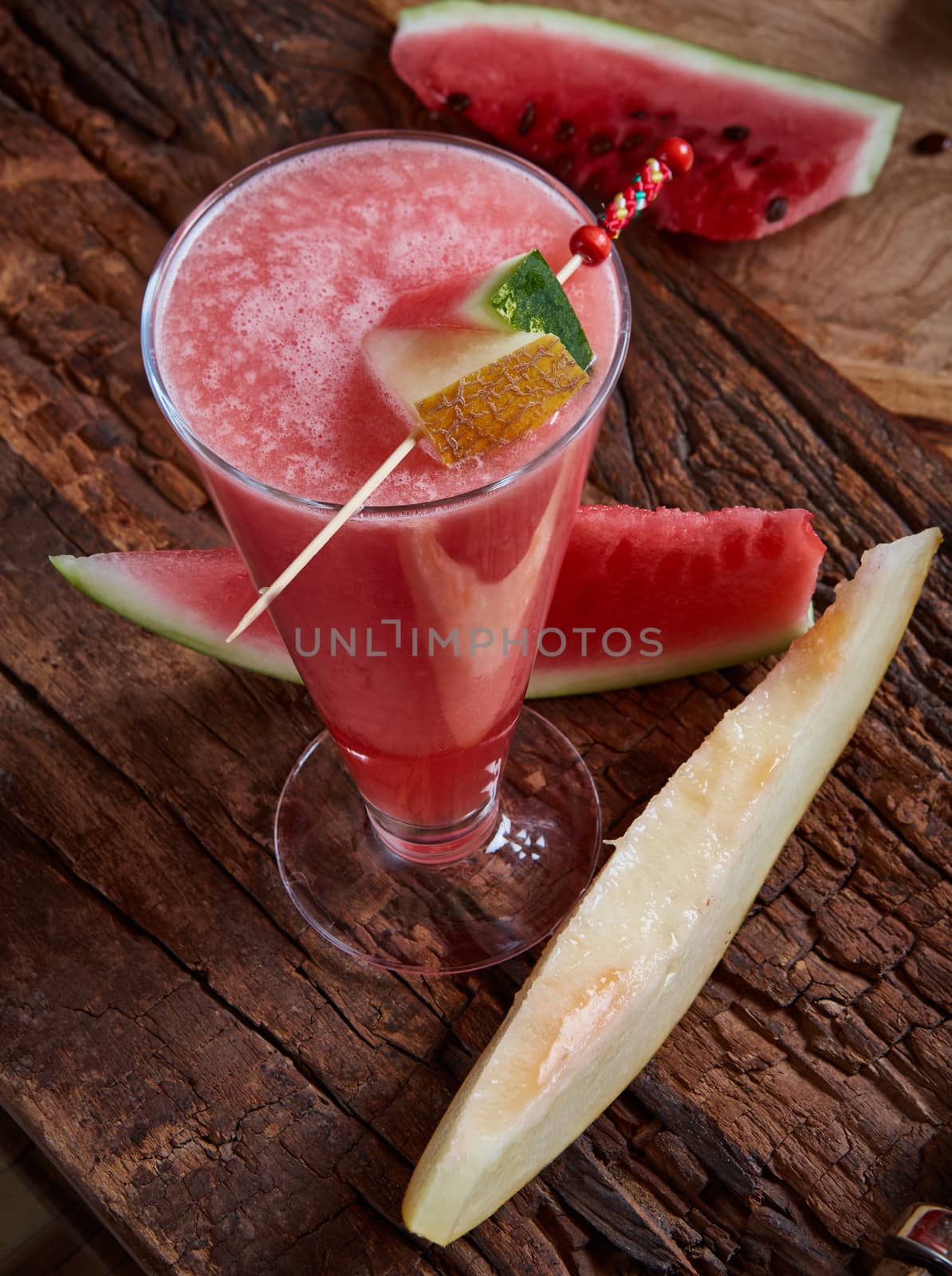 Healthy watermelon and melon smoothie with copy space on a wood background