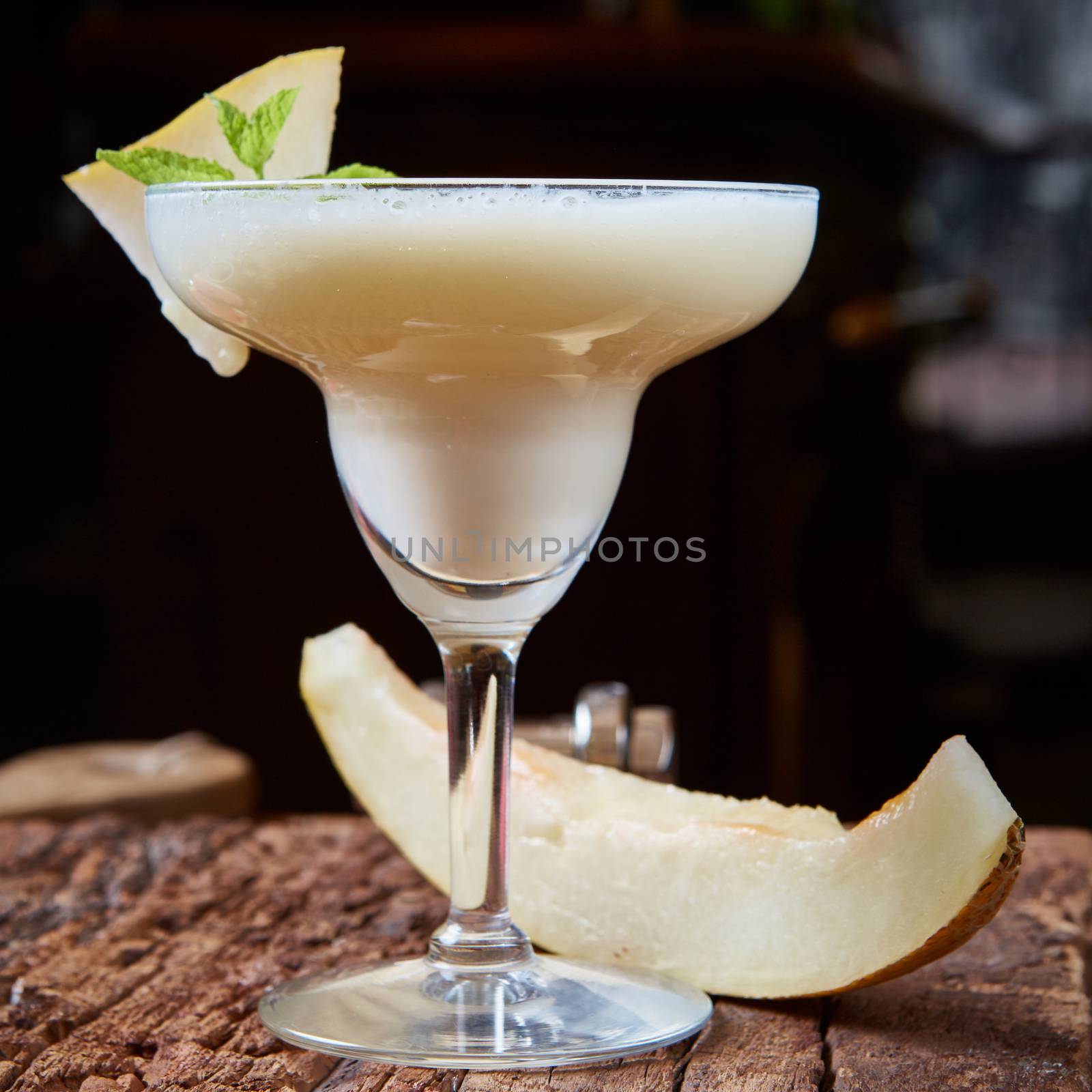 margarita melon cocktail with copy space on wooden background. 
