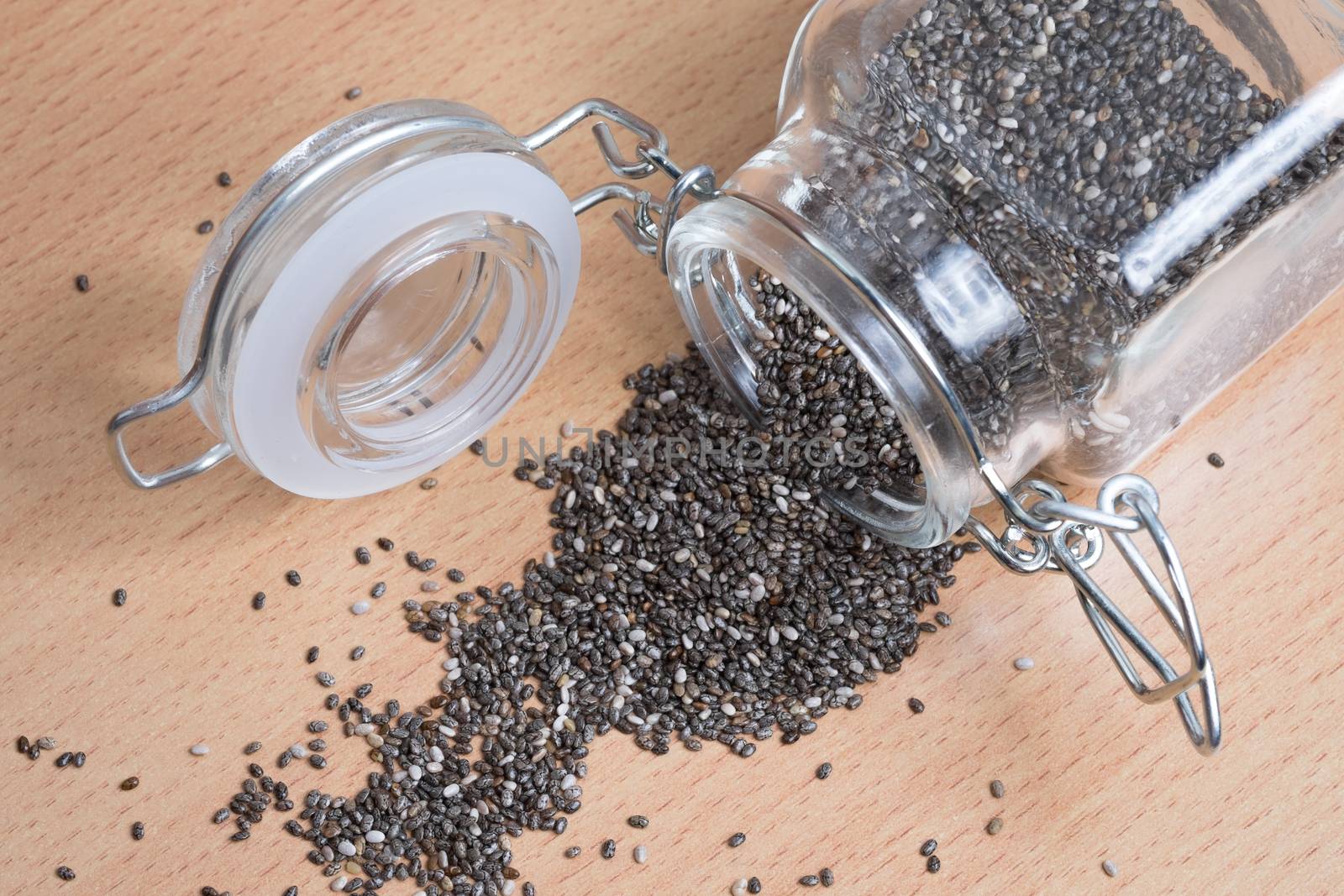 pouring chia seeds from a glass bottle